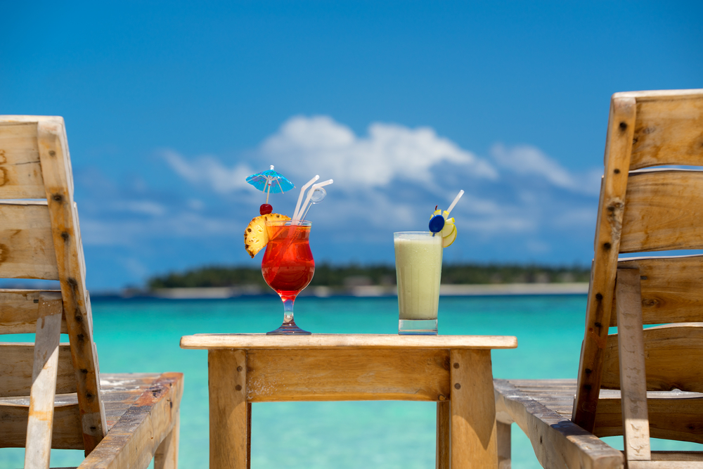 Cocktails on a wooden table overlooking the ocean at a beach bar in Aruba
